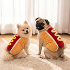 Pomeranian and pug side by side in different sizes of the hot dog costume