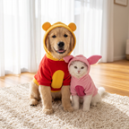 Golden retriever puppy in the Honey Bear Costume next to a kitten in the Pink Piglet Costume