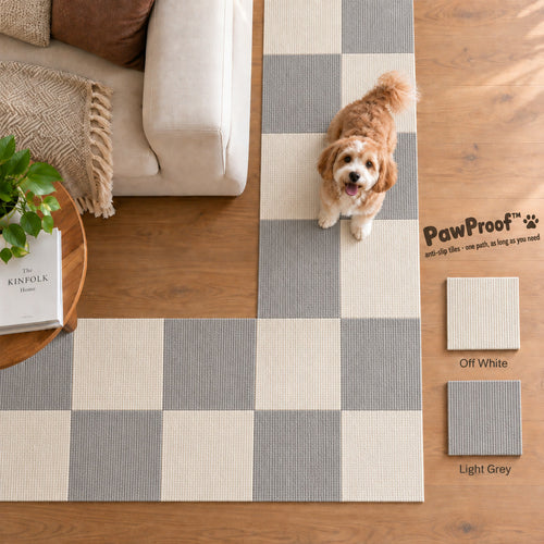 PawProof tiles in a light grey and off-white checkerboard across a living room floor, small dog sitting on them